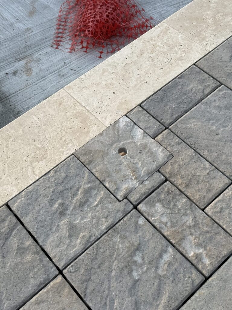 Close-up of pavers meeting stone pool coping