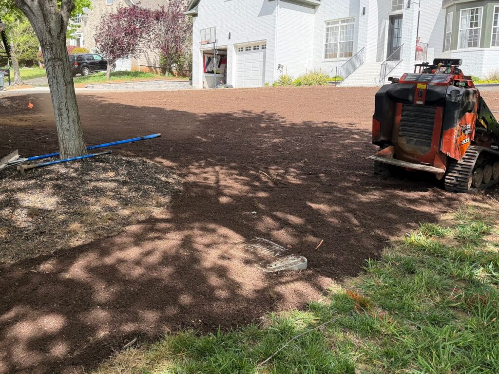Old lawn stripped down to smooth bare soil with a compact track loader before new sod